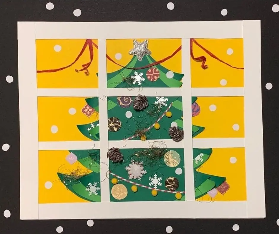 A window with a christmas tree in the middle of it.