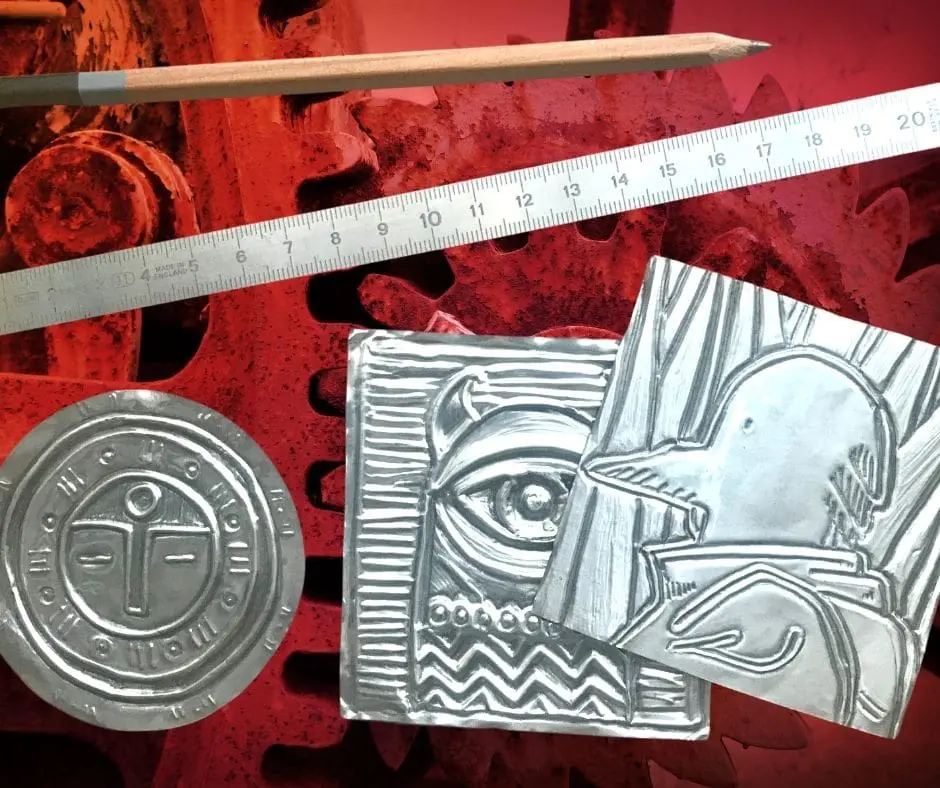 A red table with some silver objects and a ruler