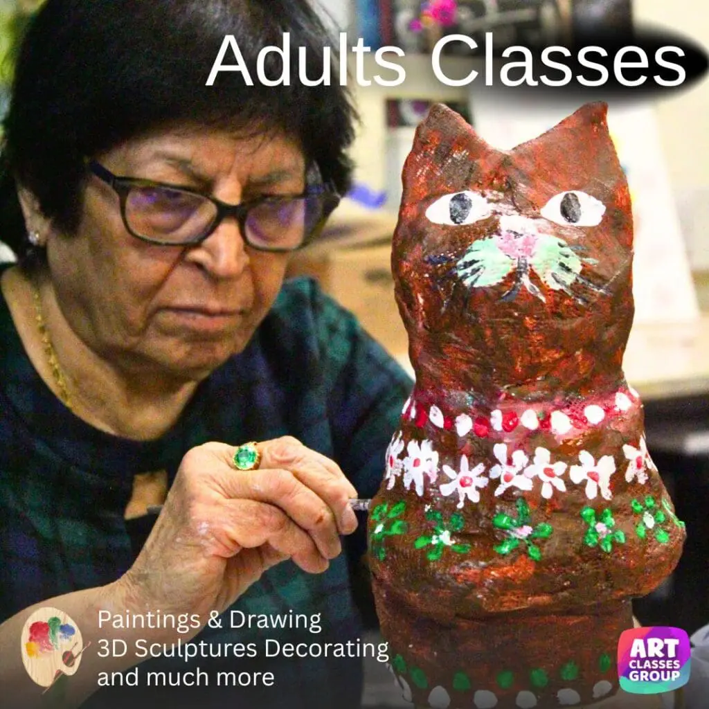Woman painting a cat sculpture in class.