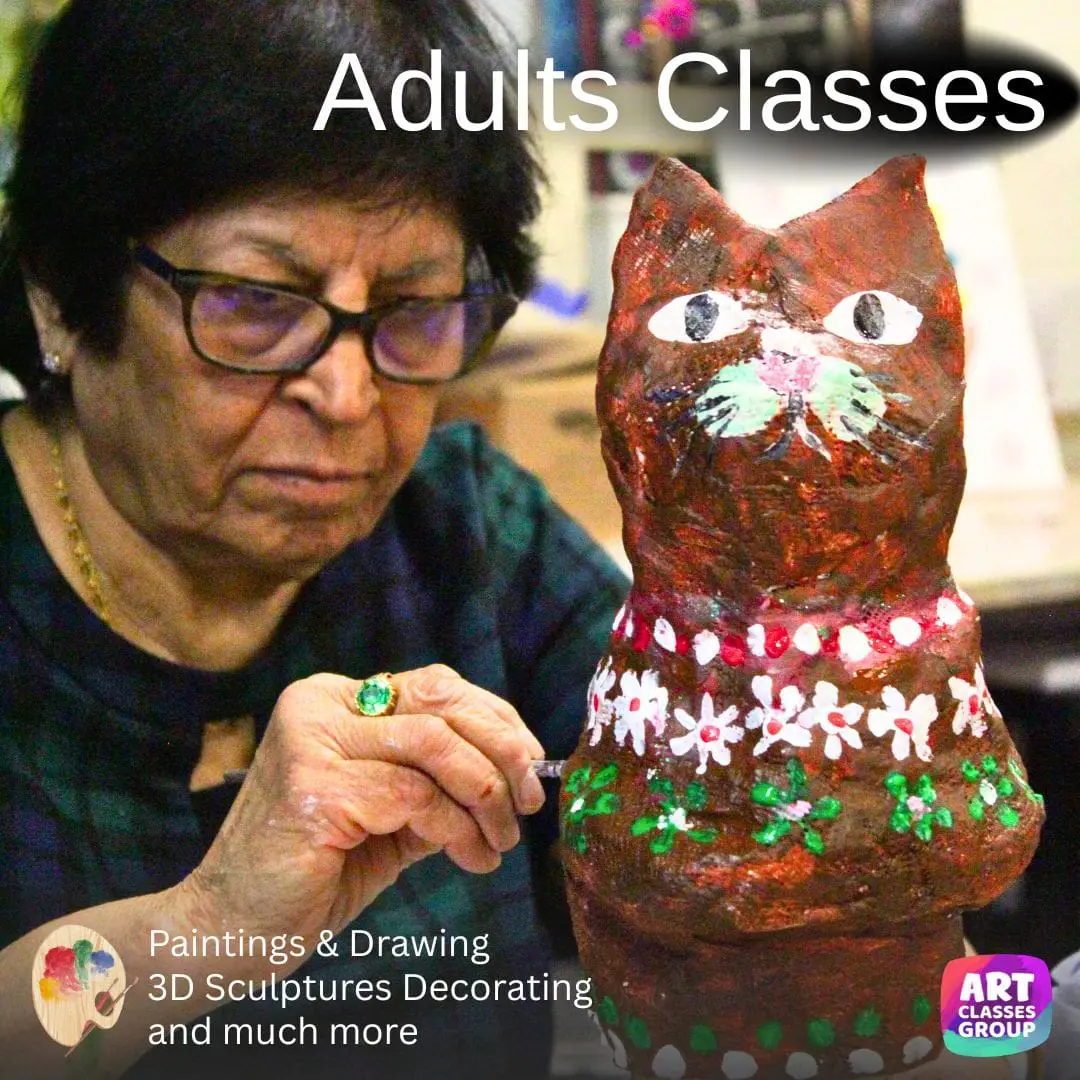 Woman painting a cat sculpture in class.