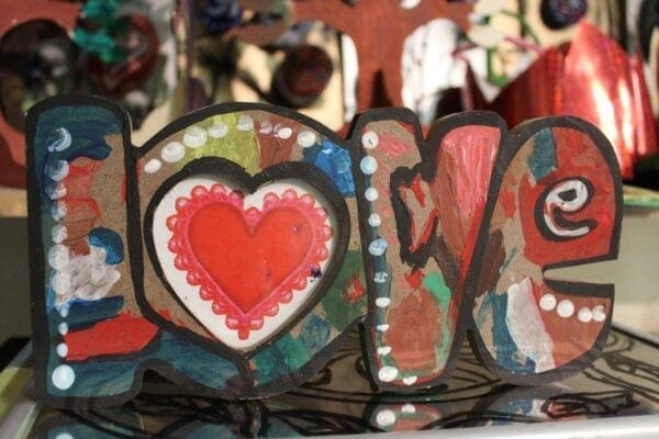 A close up of the word love with hearts painted on it