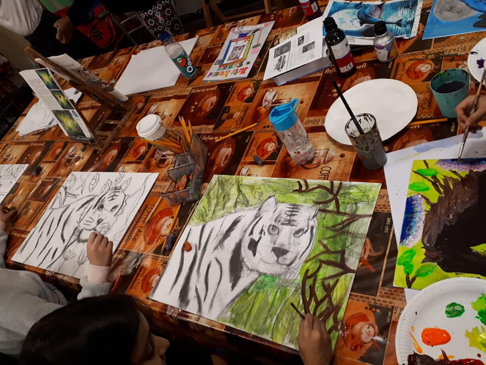 A table with paintings and brushes on it