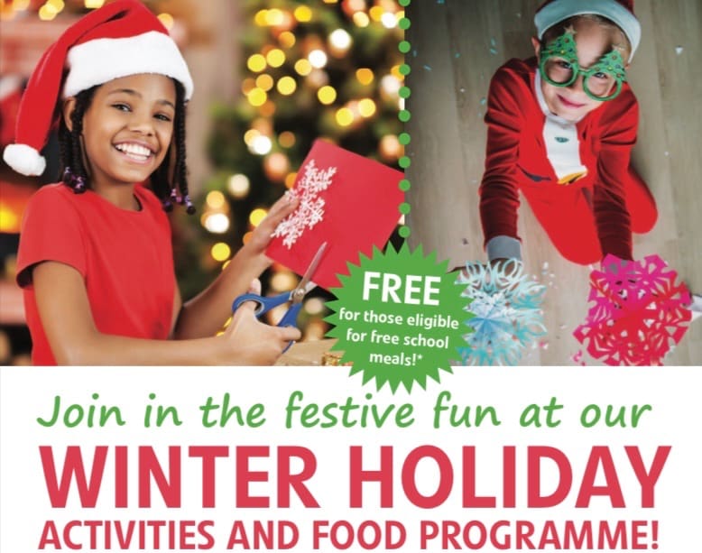 A girl holding a present in front of christmas trees.