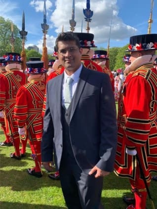 Man in suit with guards in uniform.