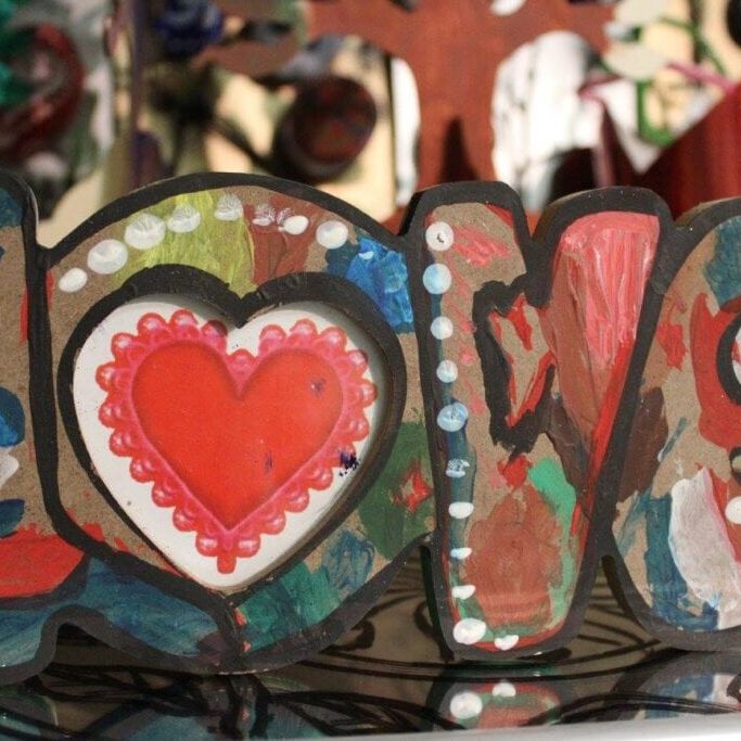 A close up of the word love with hearts painted on it