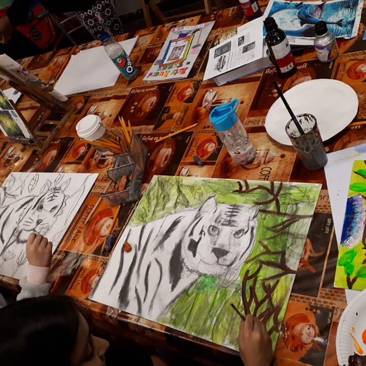 A table with paintings and brushes on it